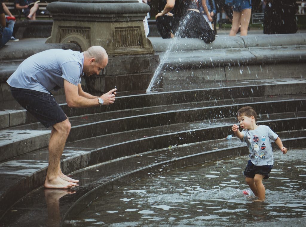 dad kids playing water