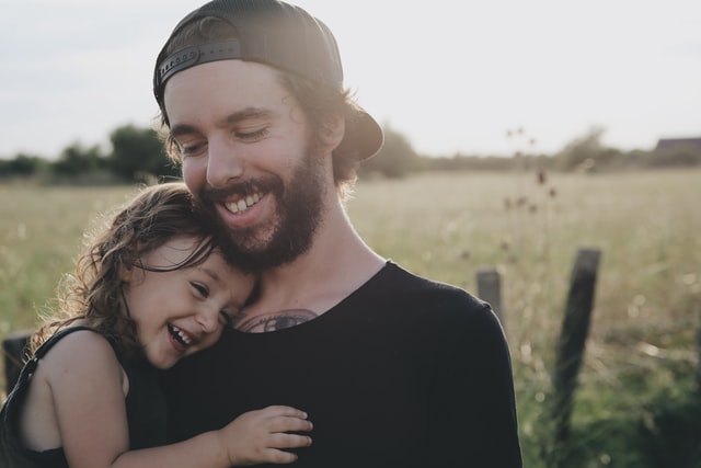 emosi pada anak dad smiling hold her daughters