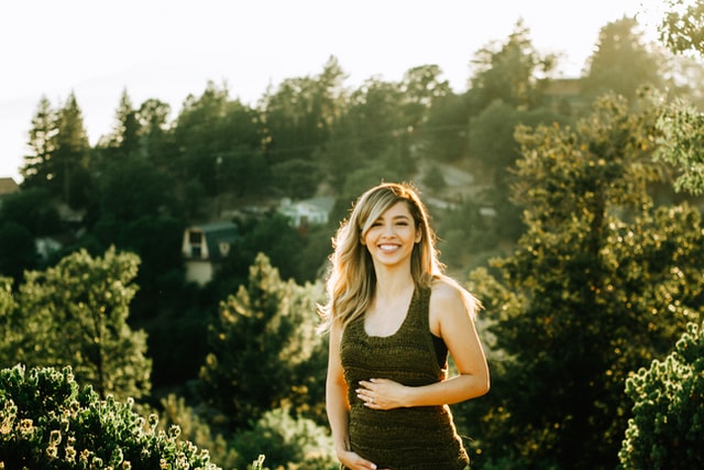 Smiling pregnant woman hold her belly.