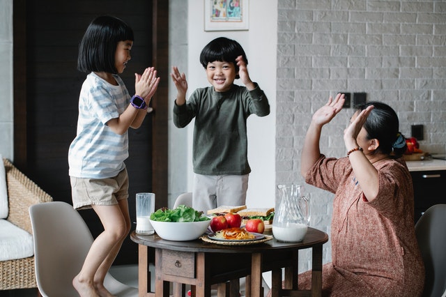 kids dancing happily with their grandmother