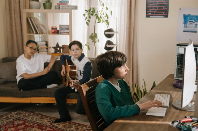Boys playing computer with his friends