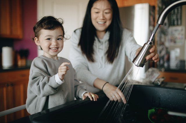 little boy doing hand wash with mom