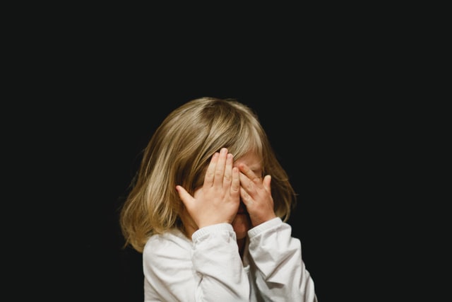 little girl cover up her face