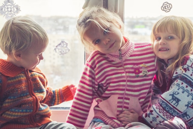 three kids wearing outer during the winter